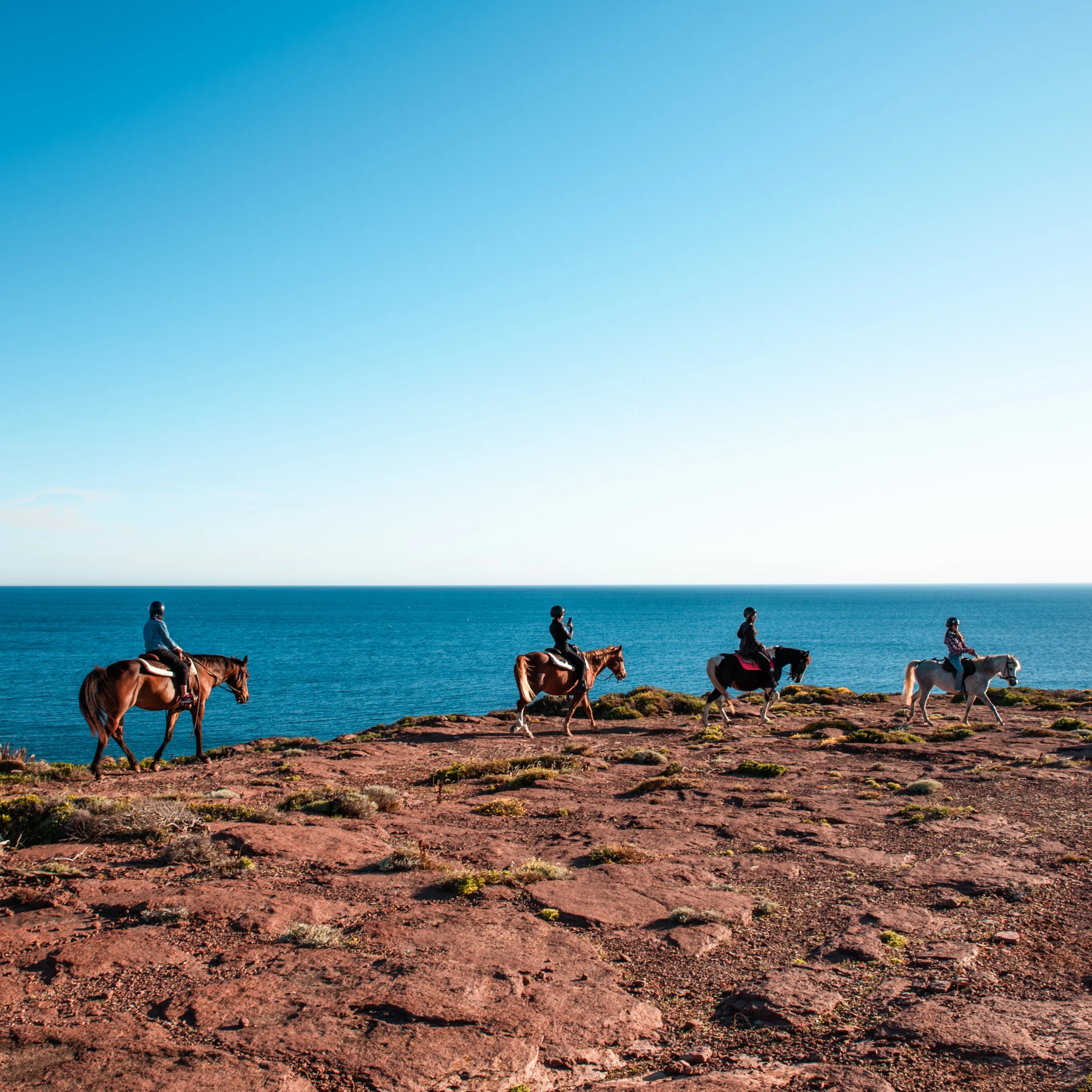 Reiter im Schritt auf der Steilküste von Sant'Antioco über dem Meer Sardiniens